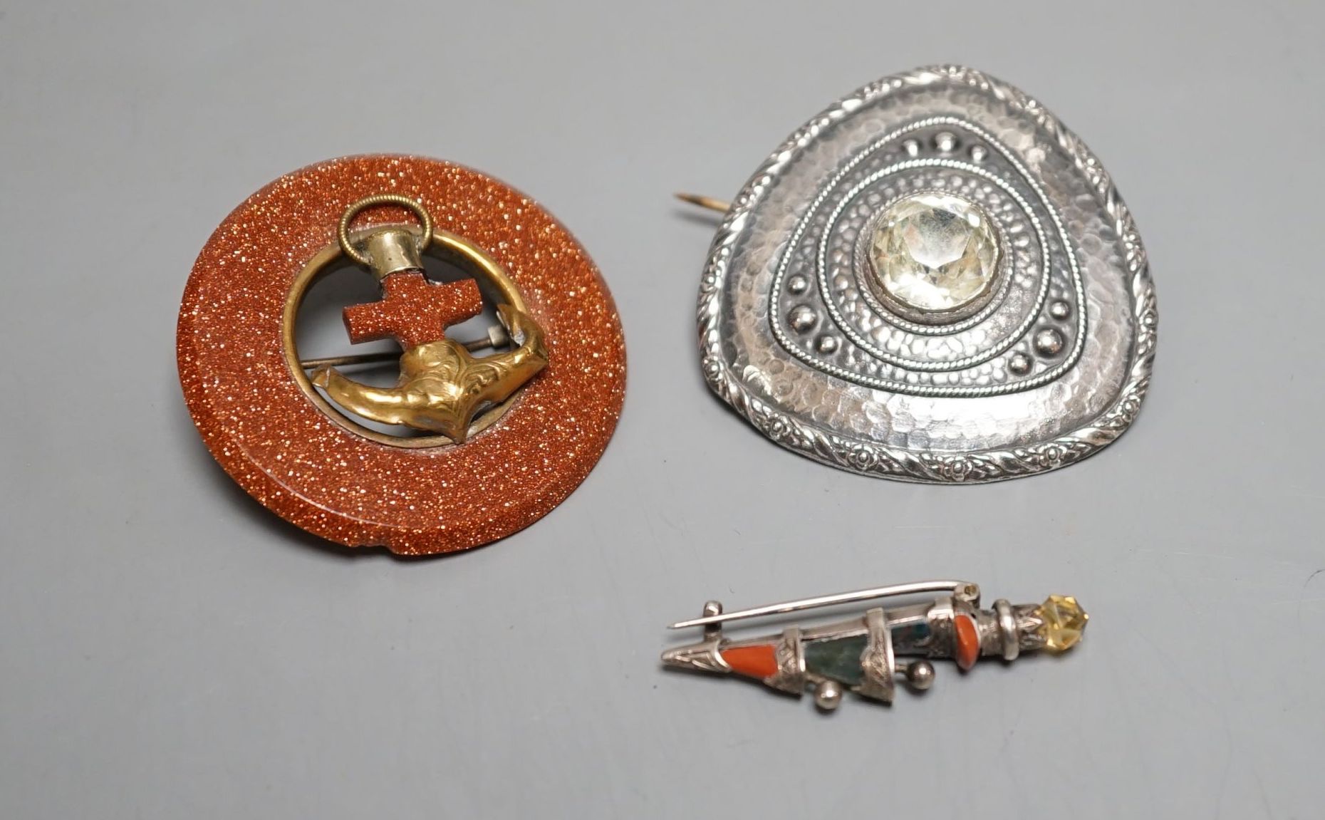 A white metal and Scottish hardstone set dirk brooch, 37mm and two other brooches.